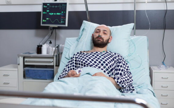 Man lying in a hospital bed after becoming ill unexpectedly.